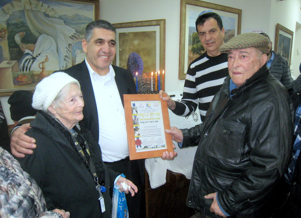 מרגש: הדלקת נר רביעי של חנוכה הודלק בחנוכייה מיוחדת ששרדה את גטו לודג'בפולין ב"בית החם לניצולי השואה" עם סגן השר ירון מזוז